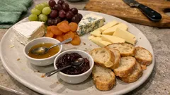 Tábua de frios para partilhar: 7 queijos, mel e fruta numa montagem simples